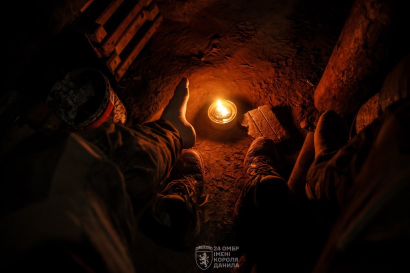 Саморобна свічка, військові гріють ноги. Дія в окопі.