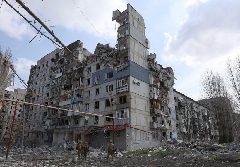 Зруйнований багатоповерховий будинок в Покровську та військові біля нього.