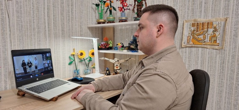 Вчитель сидить перед ноутбуком та бере участь у віртуальній екскурсії