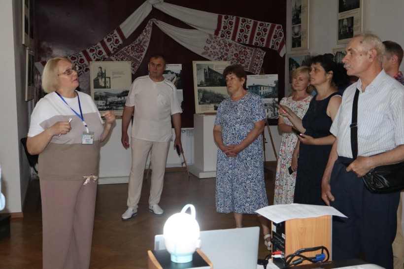Група відвідувачів у виставковій залі слухає представницю заповідника