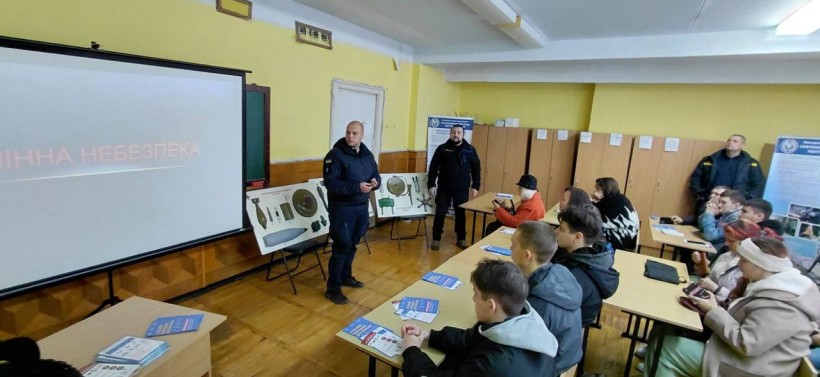 Фахівець ДСНС в аудиторії виступає перед студентами, демонструючи ЗD макети боєприпасів.