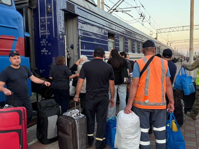 Люди сідають в евакуаційний потяг у Краматорську, їм допомагають рятувальники та представники Укрзалізниці