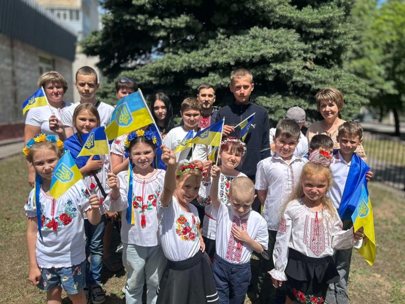 Групове фото дітей із прапорцями України на вулиці