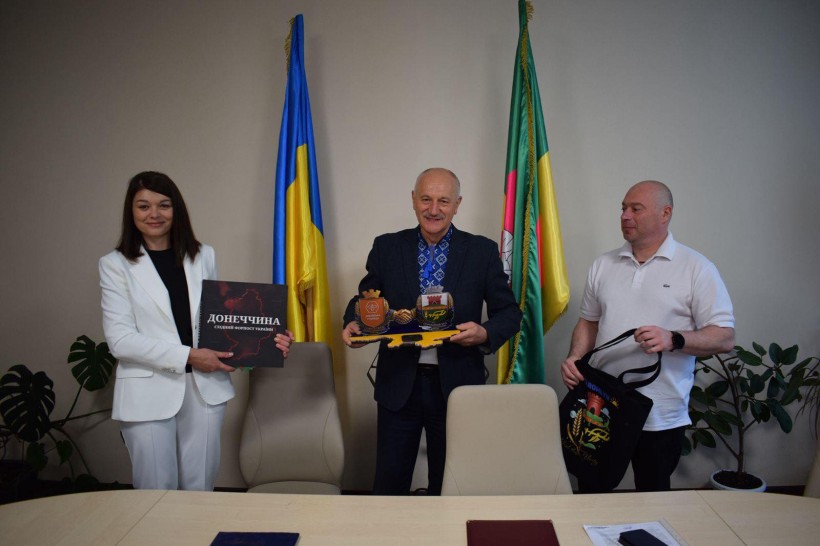 Начальниця Старомлинівської сільської військової адміністрації Альона Лєфтєрова та Софіївський селищний голова Петро Сегедій тримають подарунки