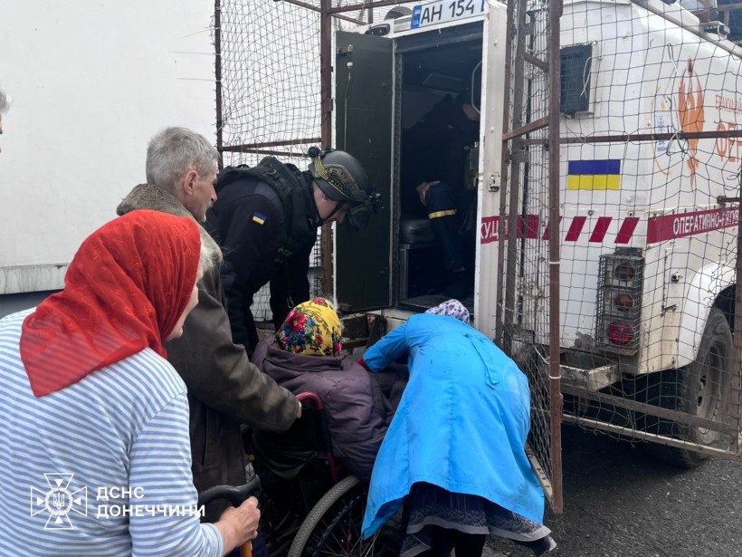 Люди похилого віку, в тому числі маломобільні, та рятувальник групи "Фенікс" здійснюють посадку на евакуацію
