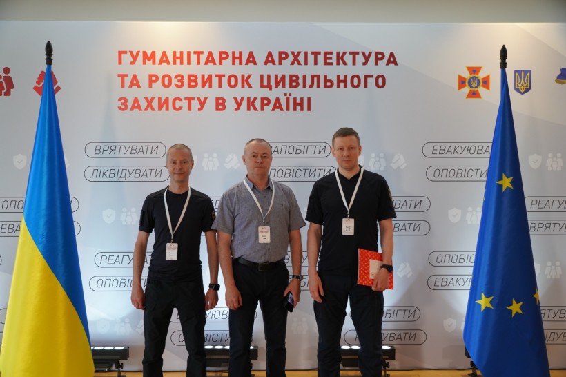 Заступник голови Донеччини Ігор Бойко разом з учасниками форуму біля фотозони, на задньому плані логотип ДСНС та партнерів.
