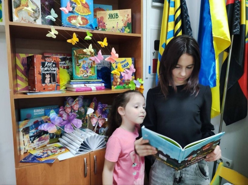 У гуманітарному центрі «З Торецьком у серці» дівчата знайомляться з яскравим світом дитячої літератури під час презентації книжкової виставки «Літо з книгою в рюкзаку»
