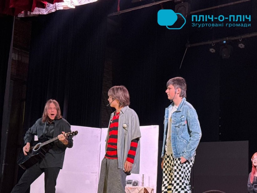 На сцені троє виконавців, один грає на гітарі, інші стоять один навпроти одного. Вони одягнені в повсякденний одяг. Настрій енергійний і захоплюючий. Сценічні прожектори освітлюють їх.