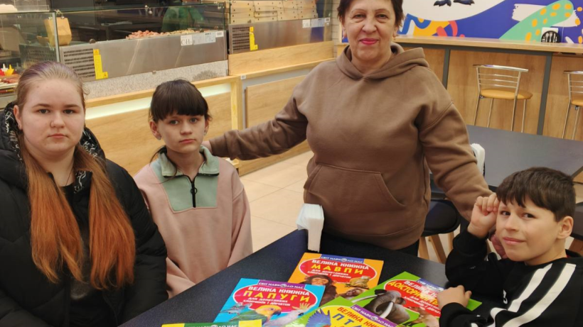 Діти з Лиманської громади за столом з книгами