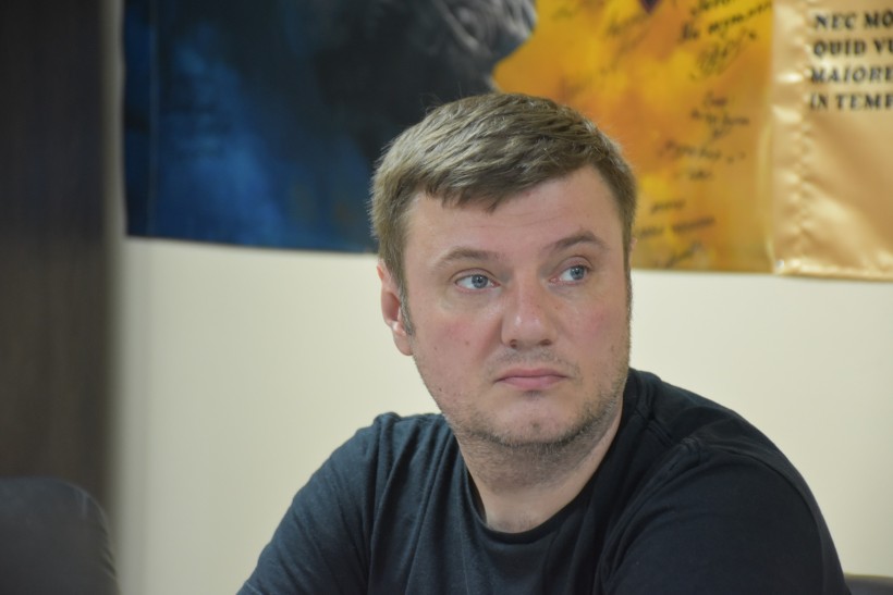 Начальник управління з питань інформатизації та цифровізації Донецької ОДА Володимир Білокопитний. Сидить за столом позаду прапори військових бригад.