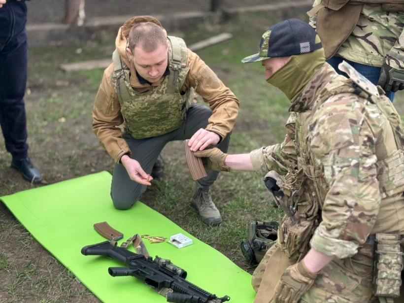 Тренер показує правильність складання зброї
