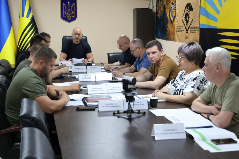 Учасники Ради оборони Донецької області спільно сидять за столом.