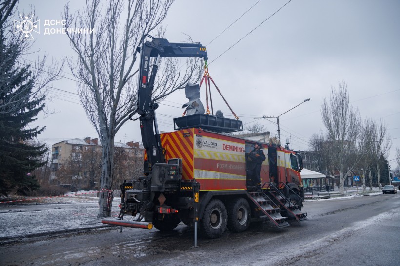 Спеціалізований автомобіль ДСНС, який за допомогою електропідйомника завантажує залишки авіаційної бомби ОДАБ-1500.  Дія у місті Краматорськ.
