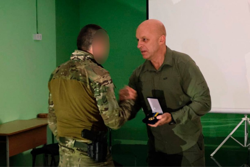 Вадим Філашкін нагороджує бійця нагрудним знаком