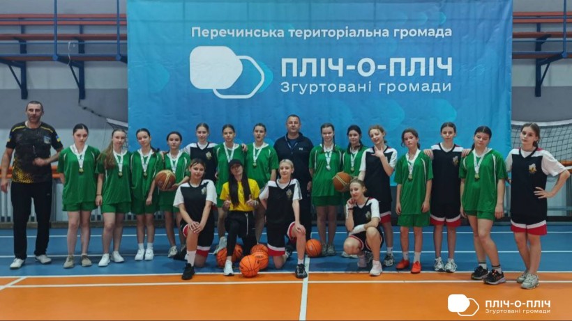 Юні спортсмени разом з тренерами позують на фоні банеру проєкту "Пліч-о-пліч"