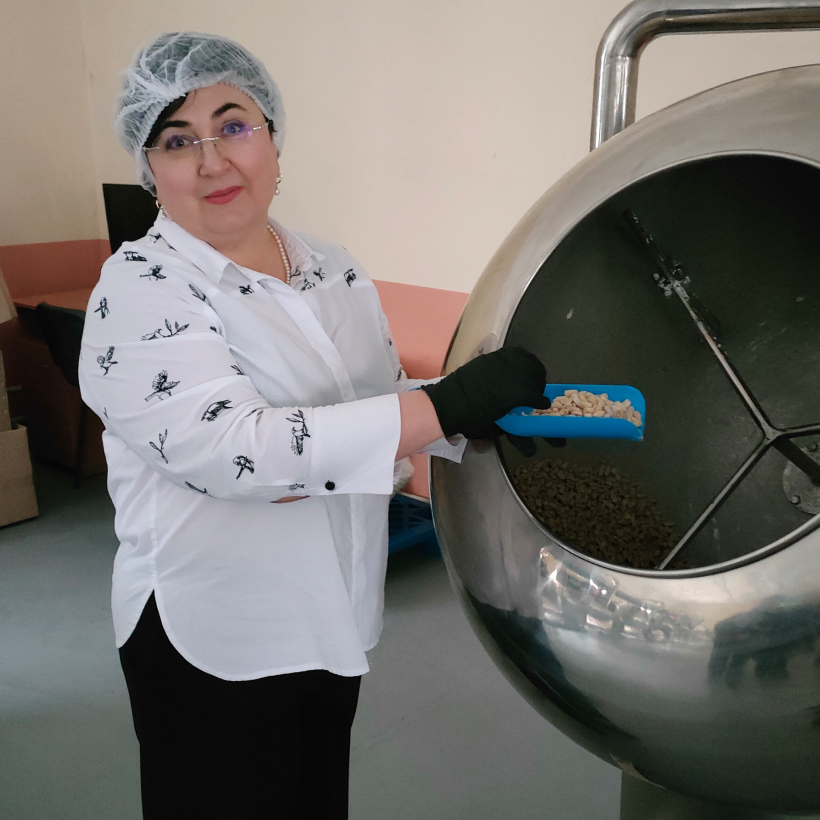 Наталія Адамова поруч з установкою, яка виробляє кондитерську продукцію