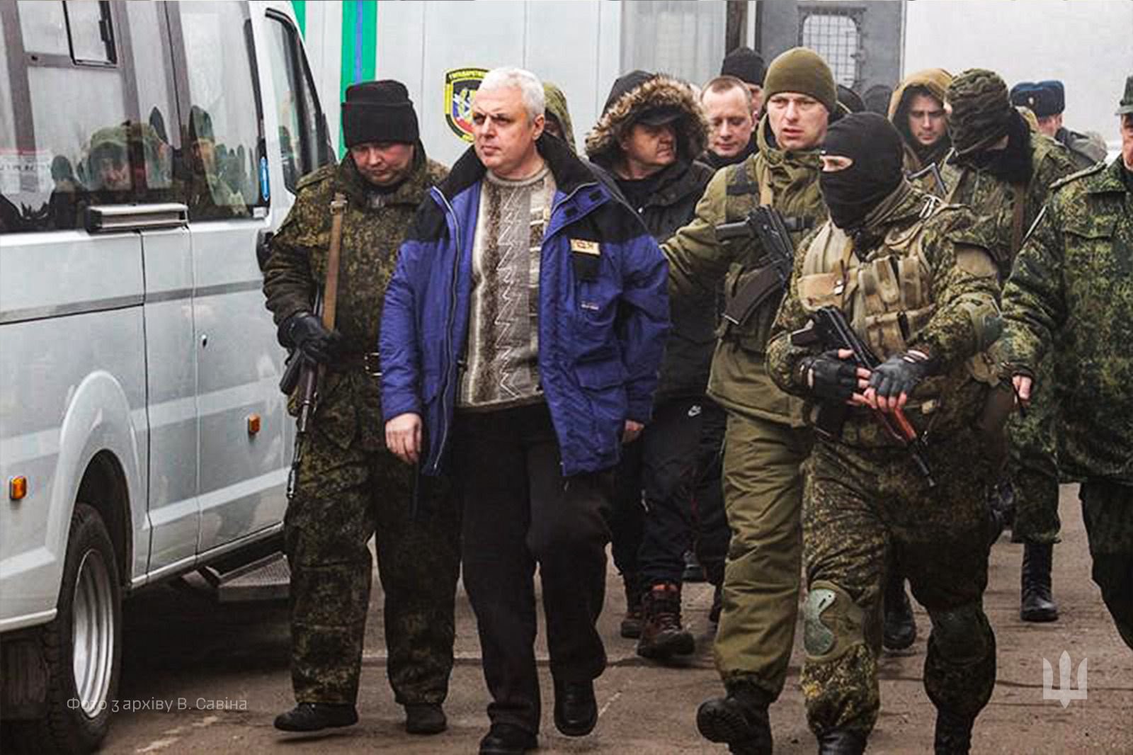 Василя Савіна ведуть под руки люди у камуфляжі з автоматами у руках.
