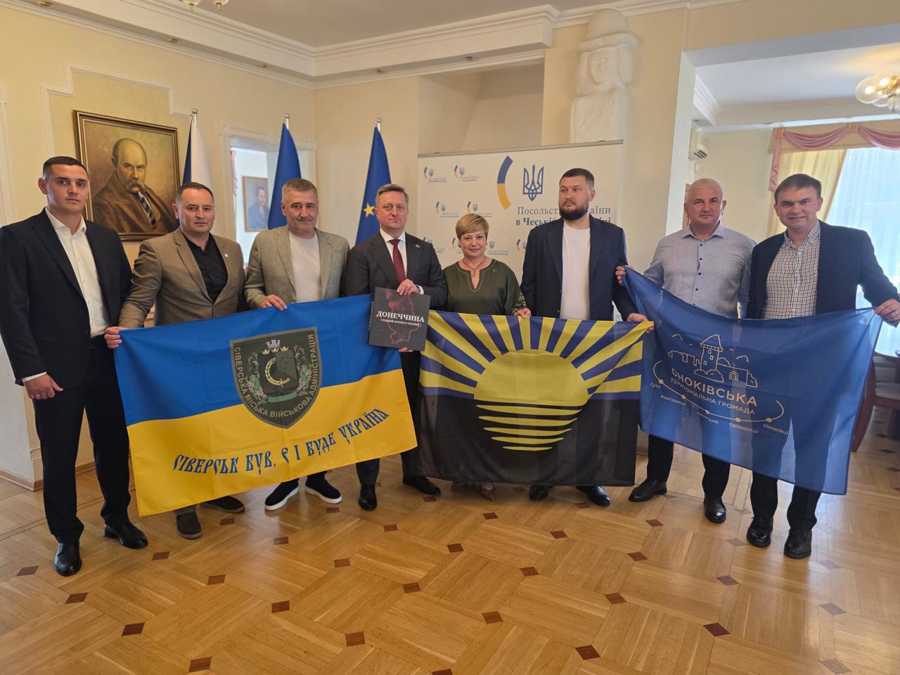 Спільне фото представників Донеччини та надзвичайним і Повноважним Послом України в Чеській Республіці Васильом Зваричем. Тримають прапори громад та Донеччини.