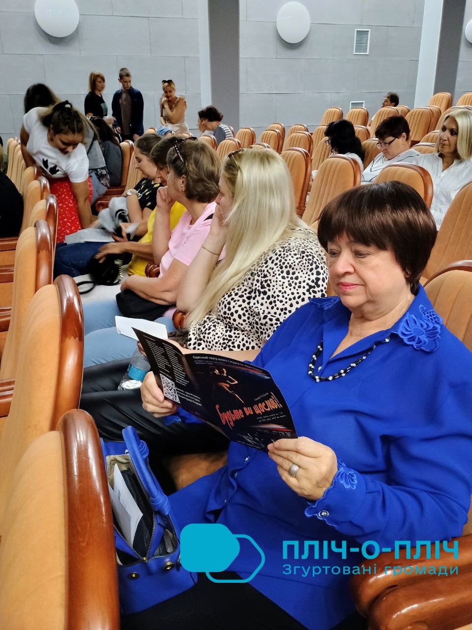 Переселенці з Донеччини сидять в залі на виставі театру
