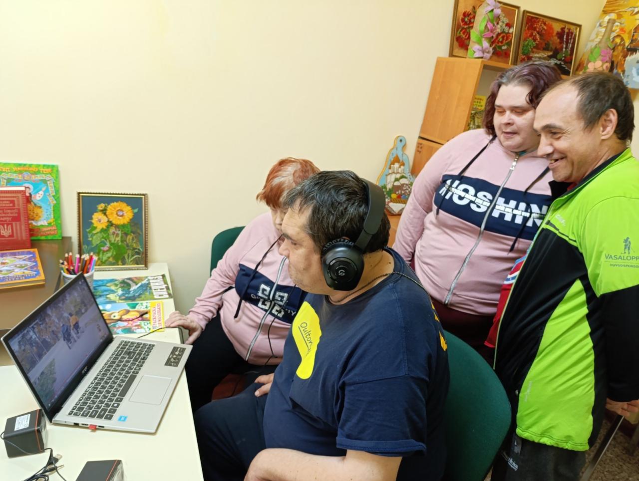 Група людей дивиться на екран ноутбука, обговорюючи інформацію
