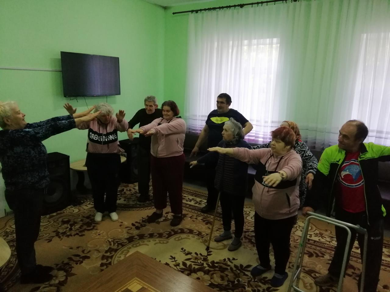 рупа людей займаються спортом у кімнаті, спілкуючись один з одним