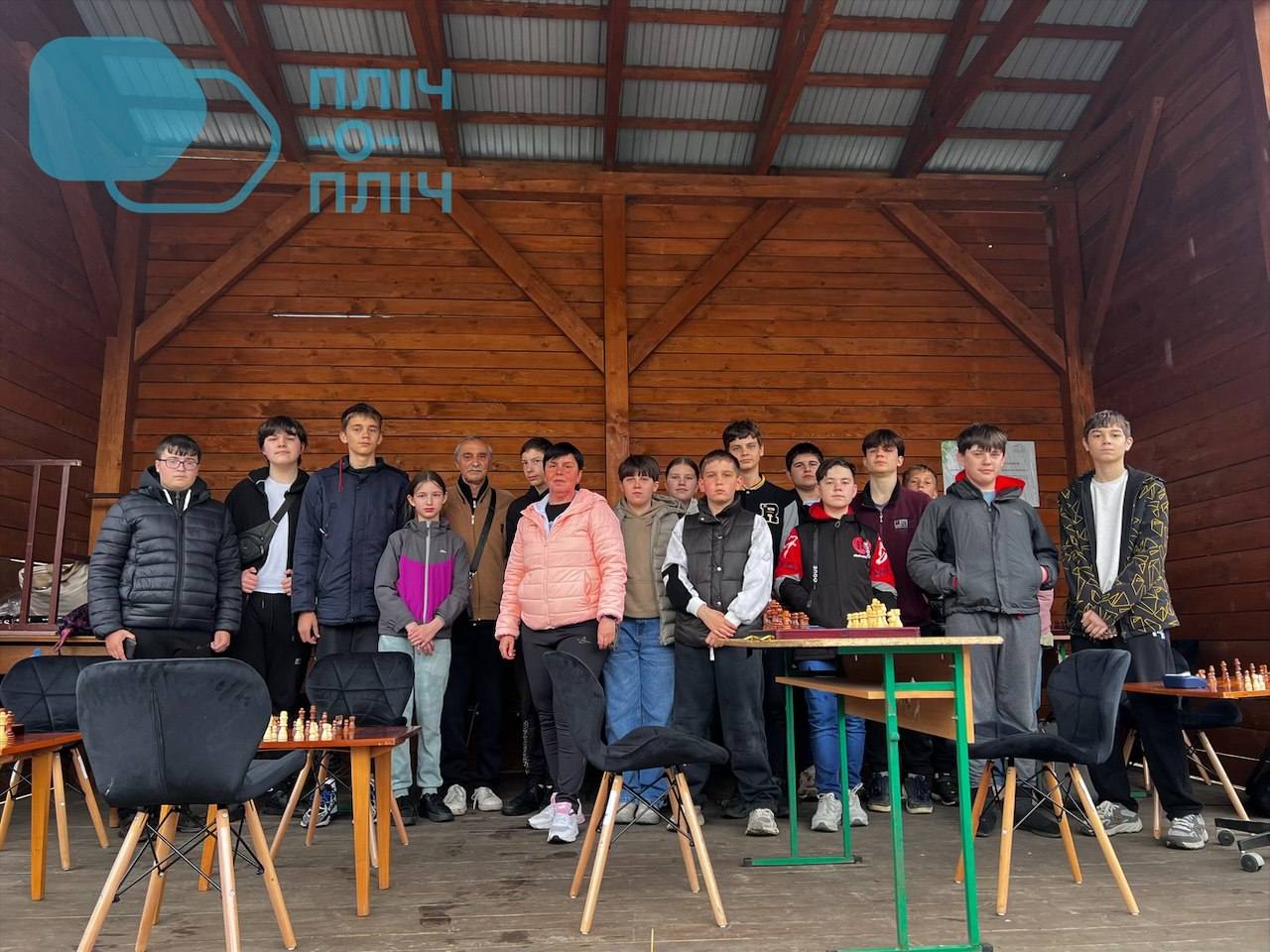 Учасники шахових змагань позують біля шахових дошок