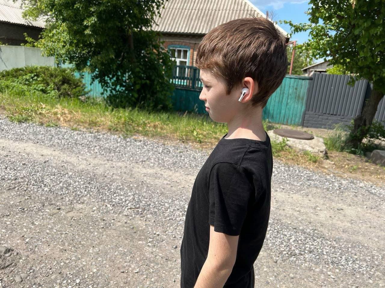 Хлопчик із навушниками йде вулицею із заплющеними очима — вправа на розвиток емпатії під час Тижня безбар’єрності