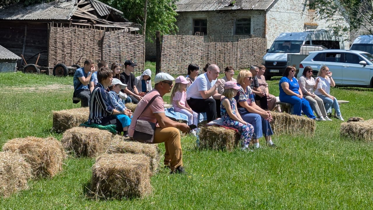 Гості свята сидять на сіні на території садиби