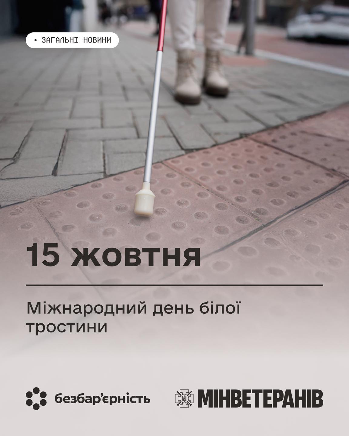 Біла тростина та ноги чоловіка на спеціальній плитці на вулиці та напис про безбар'єрність
