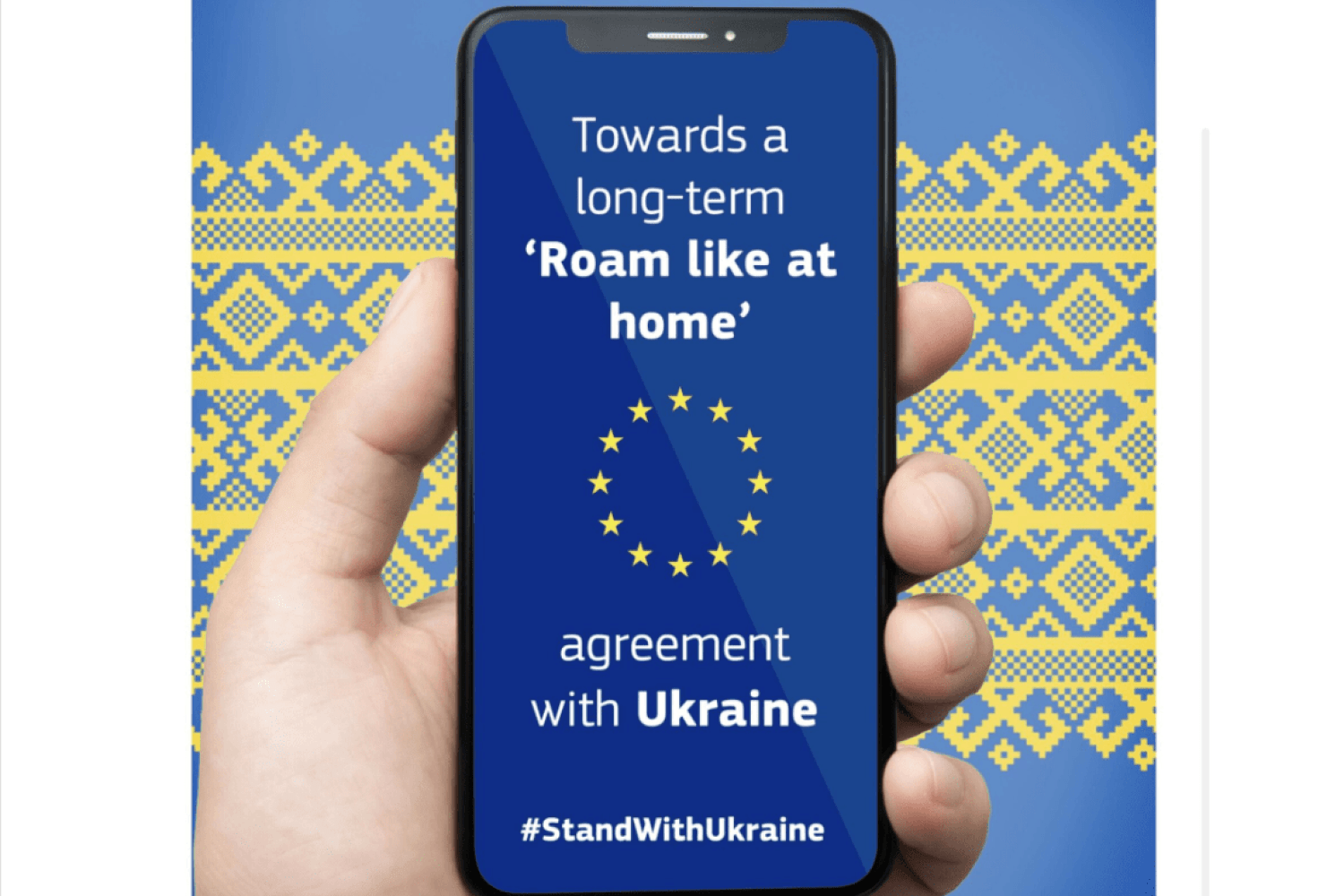 Смартфон у руці з написом про підтримку України та символікою ЄС.
