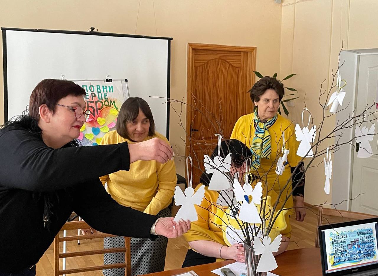 Учасники майстер-класу чіпляють янголів на гілки деревця