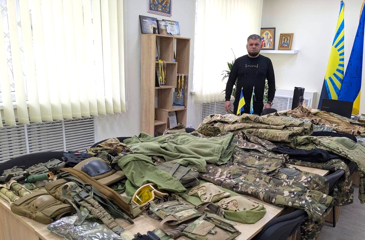 Керівник Кальчицької військової адміністрації поруч зі столом, де розкладена допомога для бійців