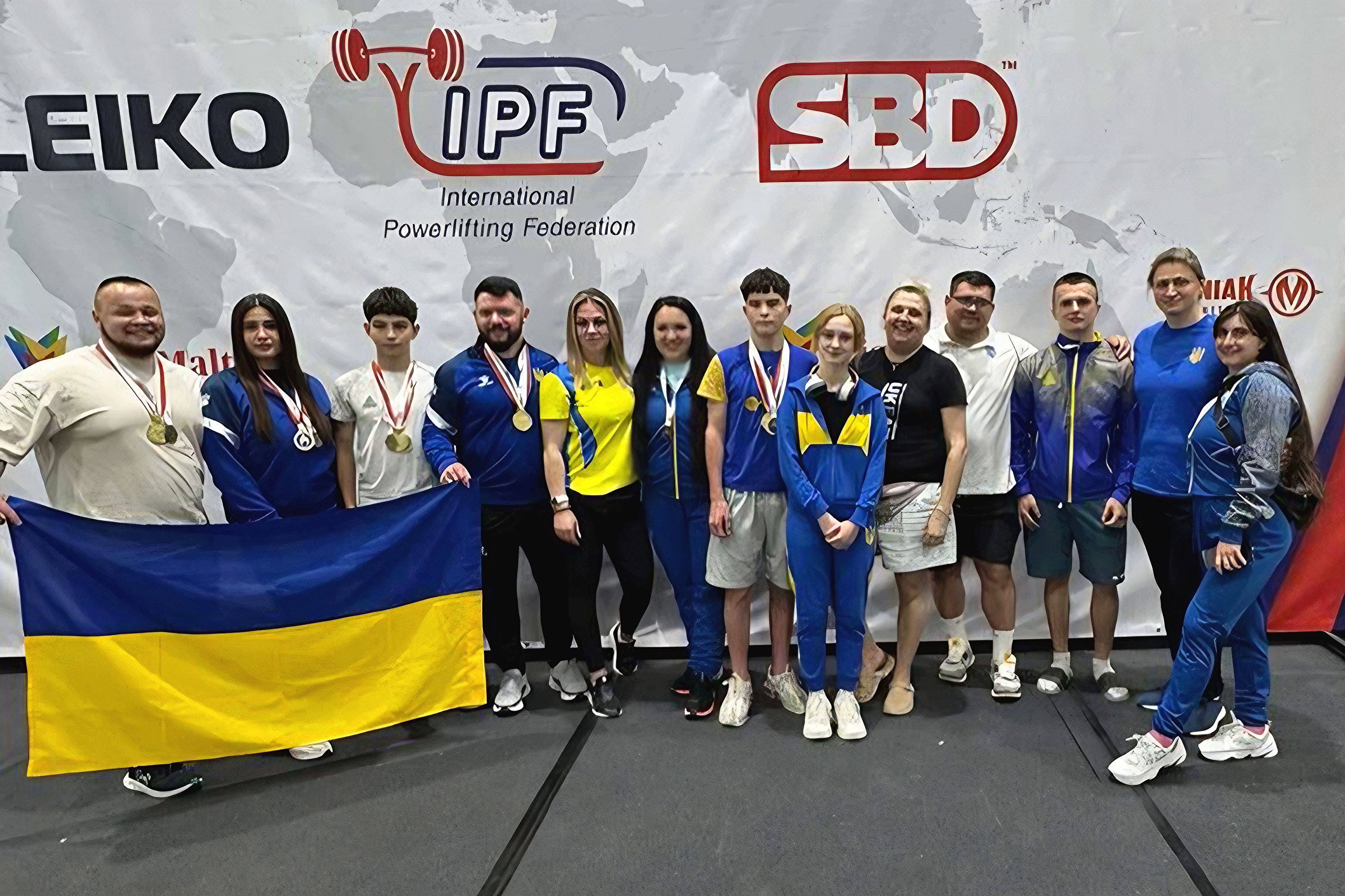 Пауерліфтери Донецької області з медалями чемпіонату світу у Варшаві тримають прапор України