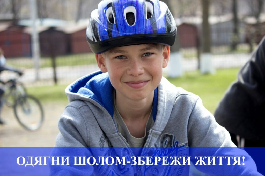 Хлопчик у шоломі на велисипеді