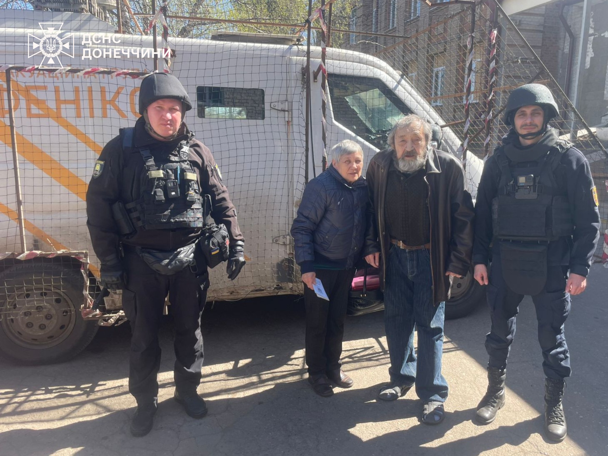 Рятувальники групи "Фенікс" разом з подружжям літнього віку біля евакомобіля