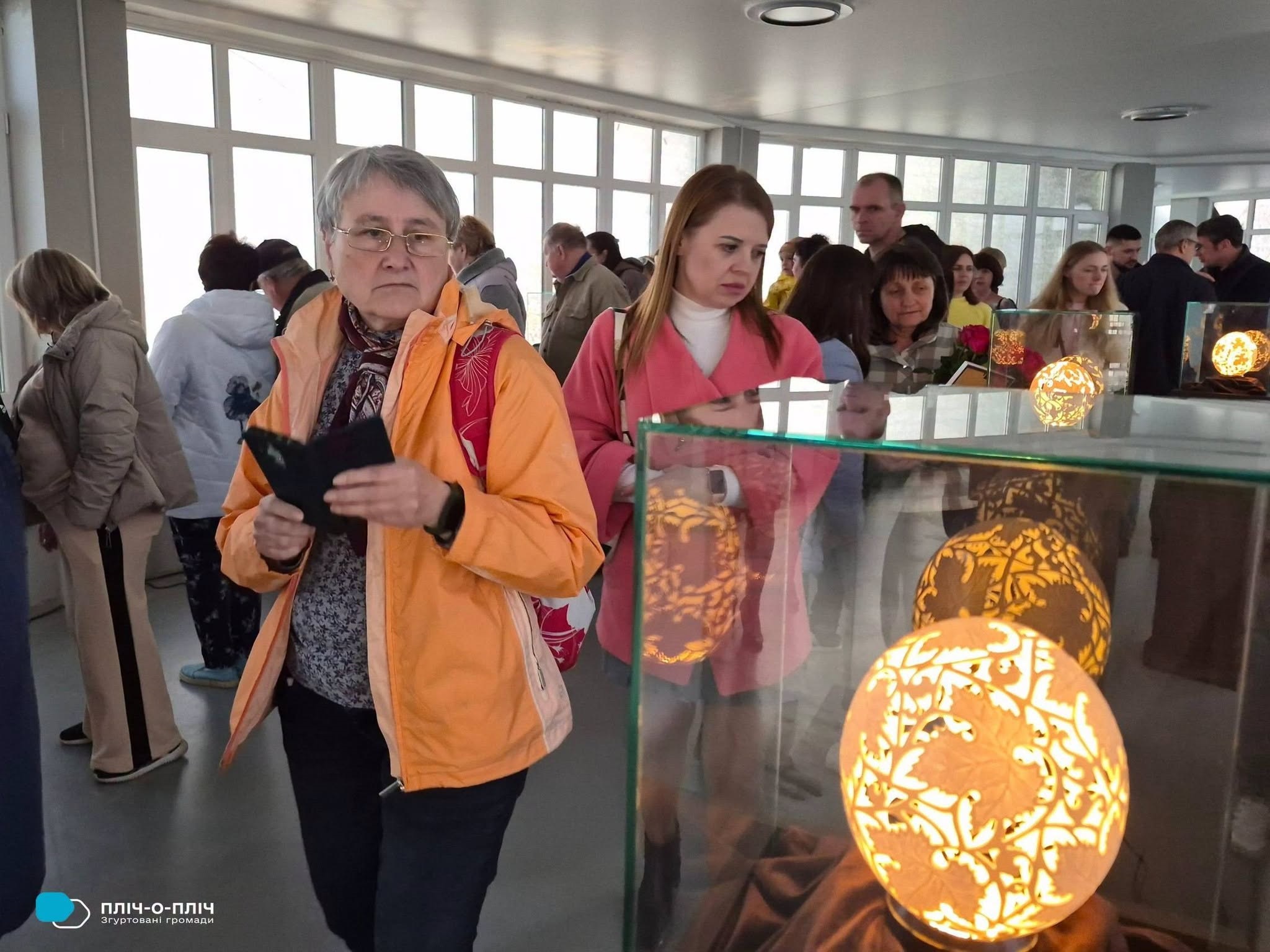 Відвідувачі виставки, уважно роздивляються експонати.