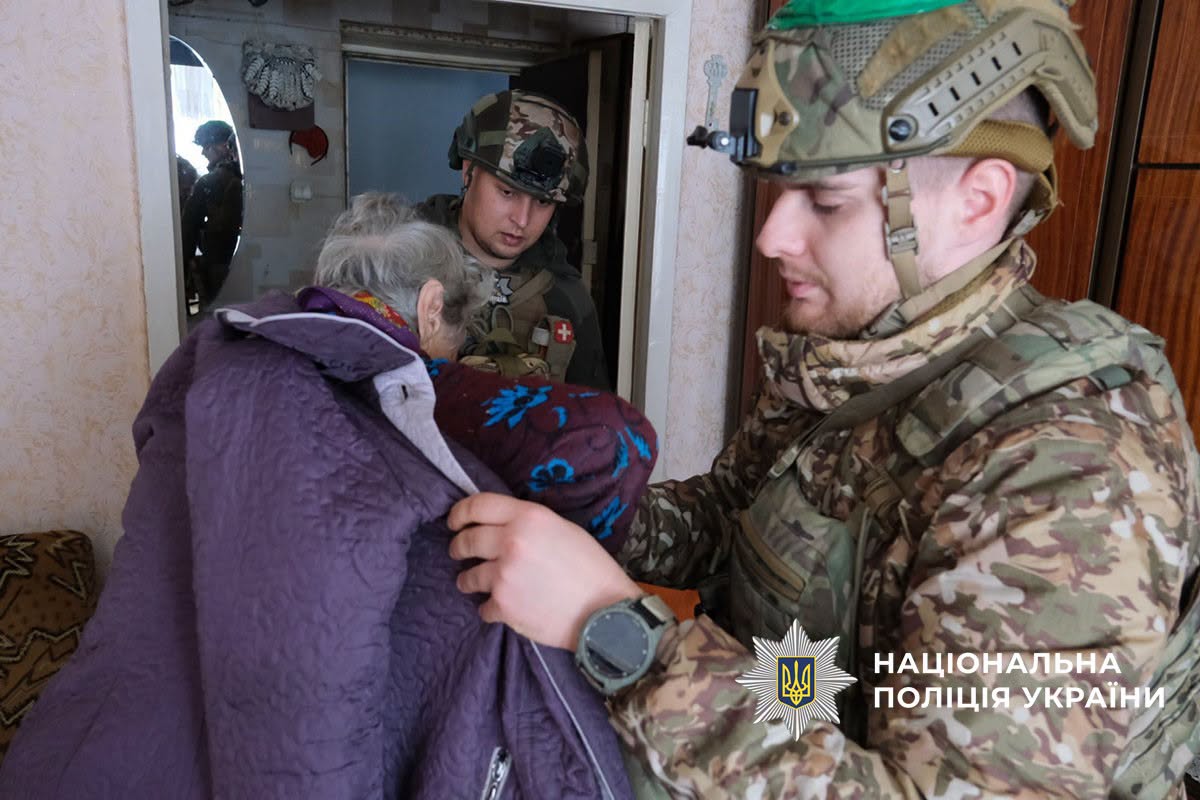 Поліцейські допомагають літній жінці одягнутись